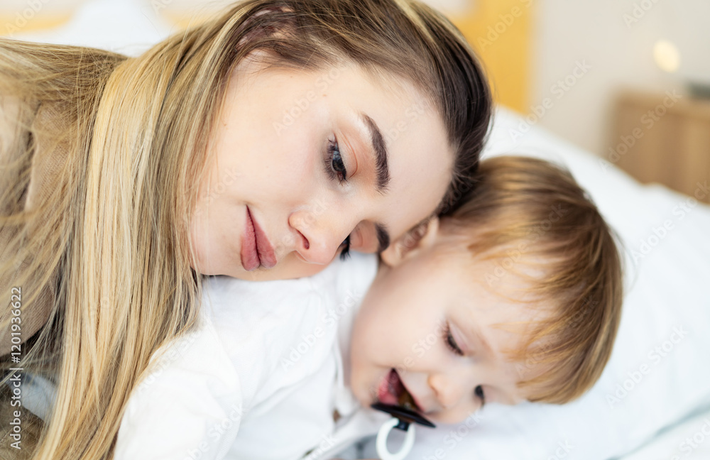 Mom and child share a moment. A mother cuddles her baby, sharing a tender moment in a cozy setting during the daytime. Mom and child share a moment. A mother cuddles her baby, sharing a tender moment in a cozy setting during the daytime.