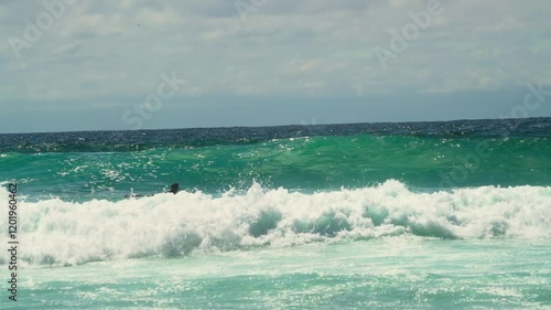 big waves in the sea with young surfer on board