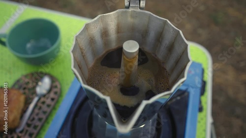preparing coffee in an old Italian coffee maker for breakfast outdoors in nature
