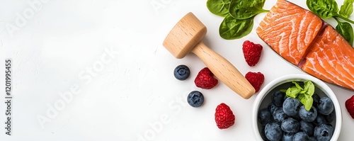 Health info tips concept. Fresh salmon, berries, and a wooden mallet on a white surface, showcasing culinary ingredients.