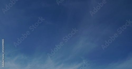 Timelapse of soft white cumulus clouds move in the blue sky. The background of light calm clouds changes shape in cloudy space. Natural background, time-lapse, copy space. 4K