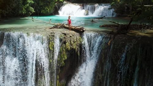 Beauty traveller woman on cascade waterfalls in Central Sulawesi. Scenic waterfall in Luwuk, photo