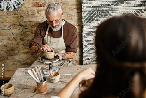 Beautiful couple hones their pottery skills, creating unique pieces while enjoying quality time. photo