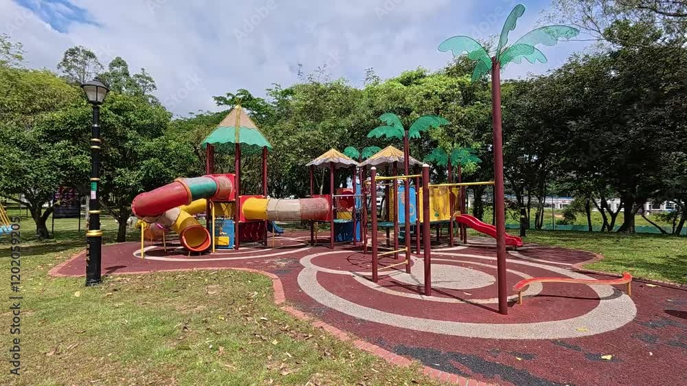 A vibrant public playground for children in a beautiful tropical park. Sunny weather enhances the cheerful outdoor atmosphere A vibrant public playground for children in a beautiful tropical park. Sunny weather enhances the cheerful outdoor atmosphere