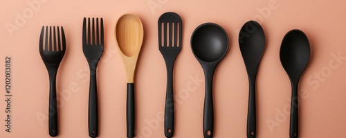 Elegant Black Cooking Utensils on Peach Background photo