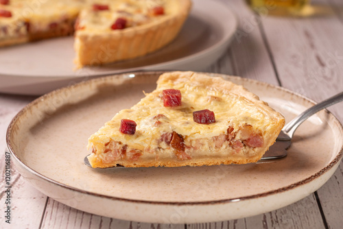 Fotografia fatia de quiche lorraine em um prato de ceramica sob uma mesa de madeira clara e