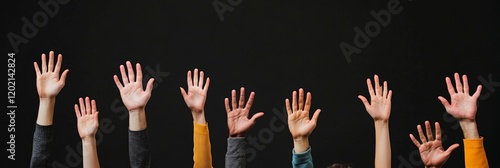 Several people raising hands to answer a question or volunteer during a conference or show against a black background, creating a sense of participation and engagement