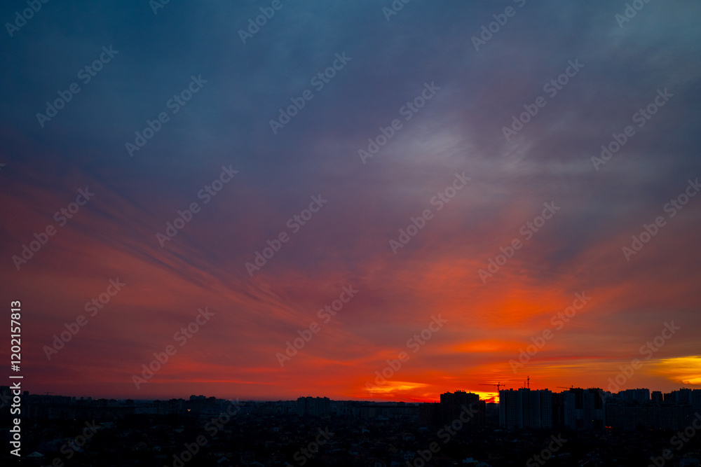 Cityscape silhouette at sunset with vibrant red and blue sky. Urban skyline during twilight. Sunset and urban landscape concept Cityscape silhouette at sunset with vibrant red and blue sky. Urban skyline during twilight. Sunset and urban landscape concept