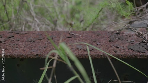 Derelict infrastructure including fuel storage tanks, concrete pipes, old metal framework. Slow lateral movement. Clip 6 photo