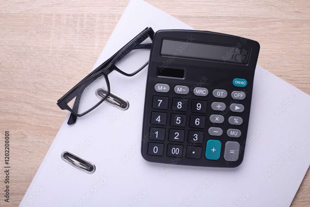 Black classic calculator with eyeglasses and folder on table. Business concept. Top view Black classic calculator with eyeglasses and folder on table. Business concept. Top view