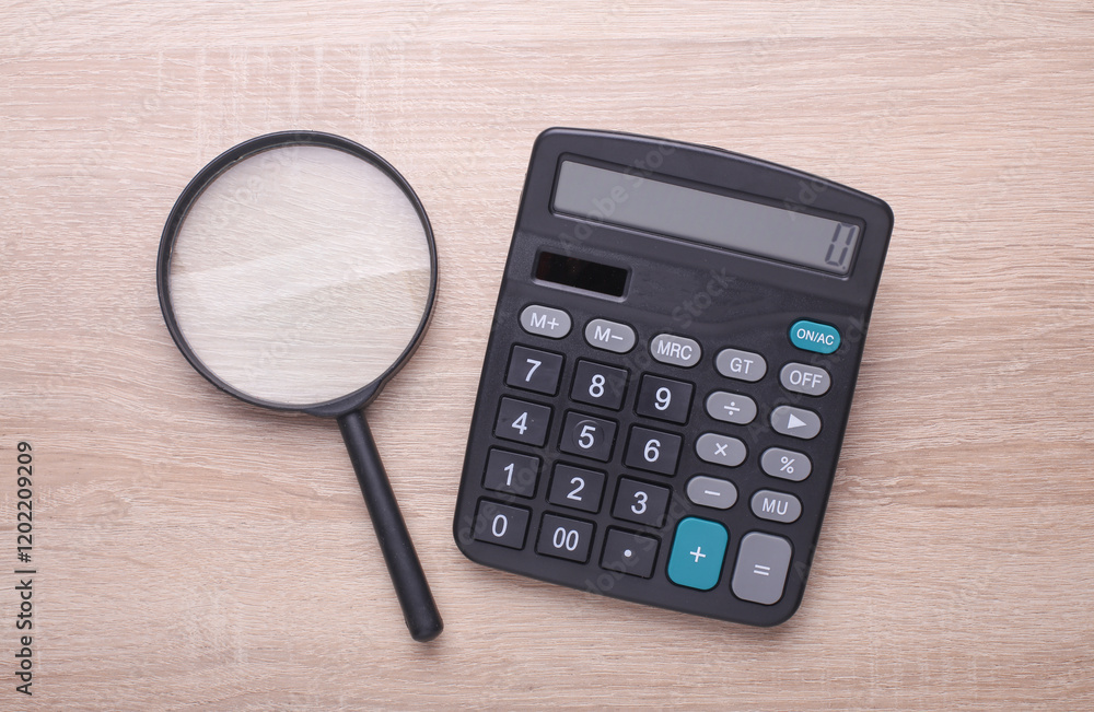 Calculator with magnifying glass on the table Calculator with magnifying glass on the table