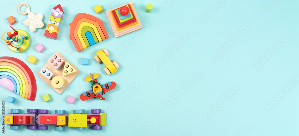 Baby kids toy frame background. Teddy bear, colorful wooden educational, sensory, sorting and stacking toys for children on light blue background. Top view, flat lay Baby kids toy frame background. Teddy bear, colorful wooden educational, sensory, sorting and stacking toys for children on light blue background. Top view, flat lay