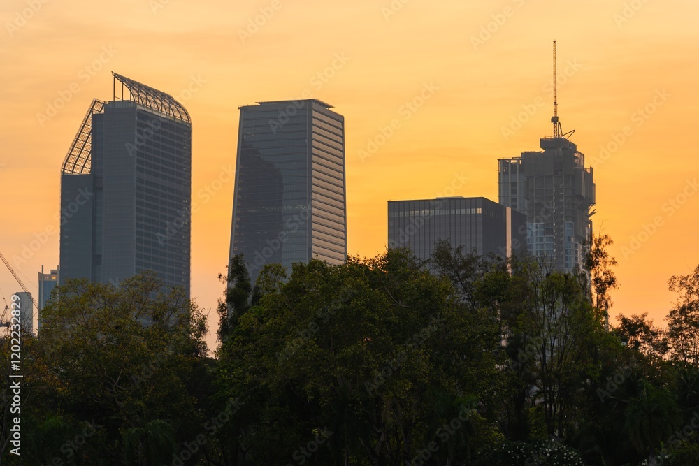 Sunset view of Bangkok's skyline with modern buildings and silhouettes in the foreground Sunset view of Bangkok's skyline with modern buildings and silhouettes in the foreground