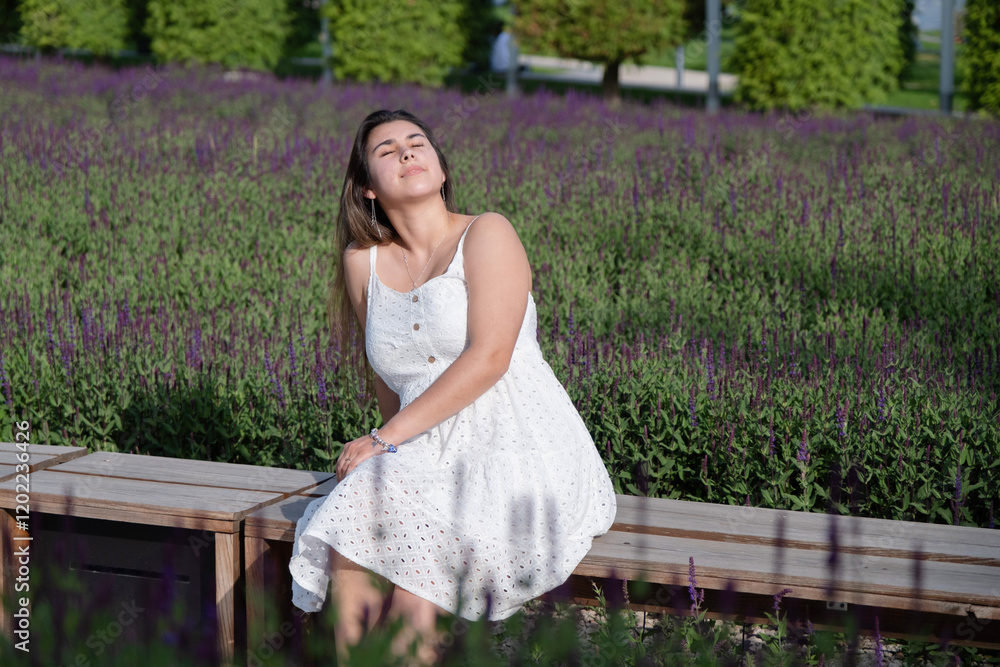 pretty young woman in white dress sitting at the sage flower field. pretty young woman in white dress sitting at the sage flower field.