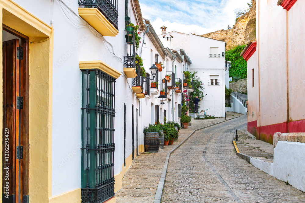 Fototapeta premium A picturesque, colorful traditional street in the White Village of Zahara de la Sierra in the Andalusian region of Southern, Spain. 