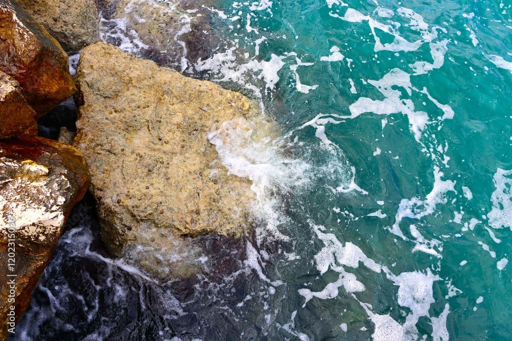 Obraz premium Sea wave rolling on the coast rocks