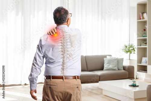 Rear view shot of an elderly man with pain in shoulder photo