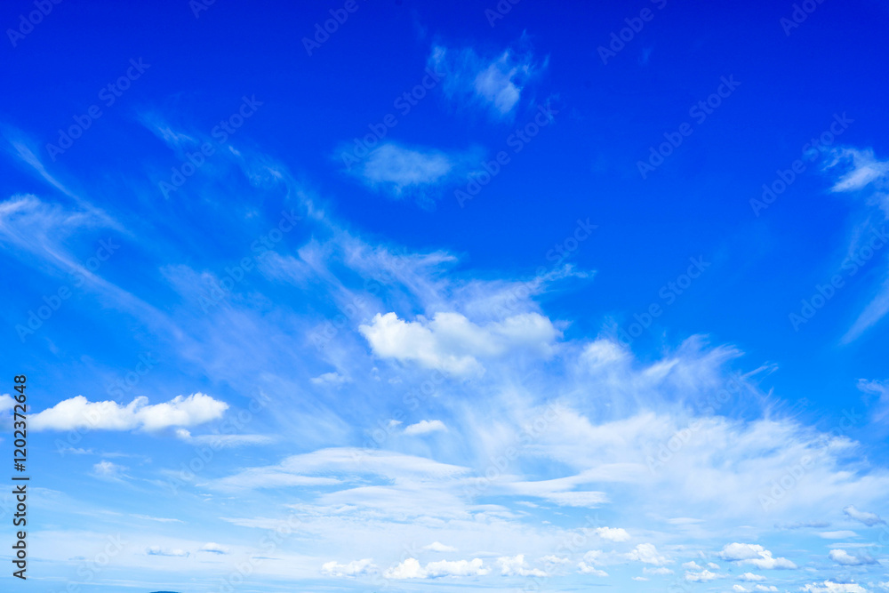Fototapeta premium Ярко-голубое небо с тонкими кудрявыми облаками в солнечный, ясный день