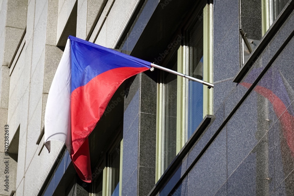 Czech national flag waving on modern building reflected on grey marble wall