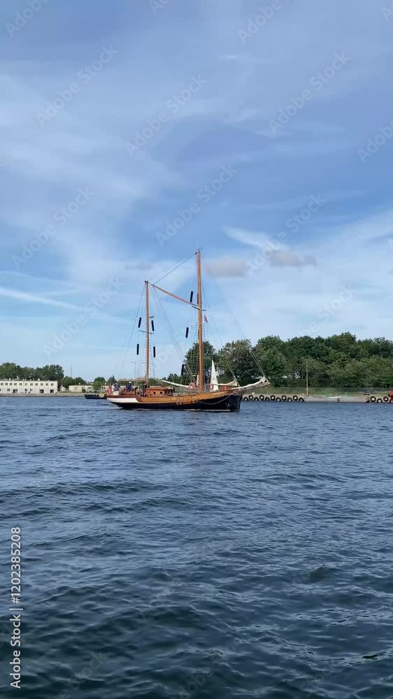 Sailing ship gliding through serene waters against a clear blue sky Sailing ship gliding through serene waters against a clear blue sky