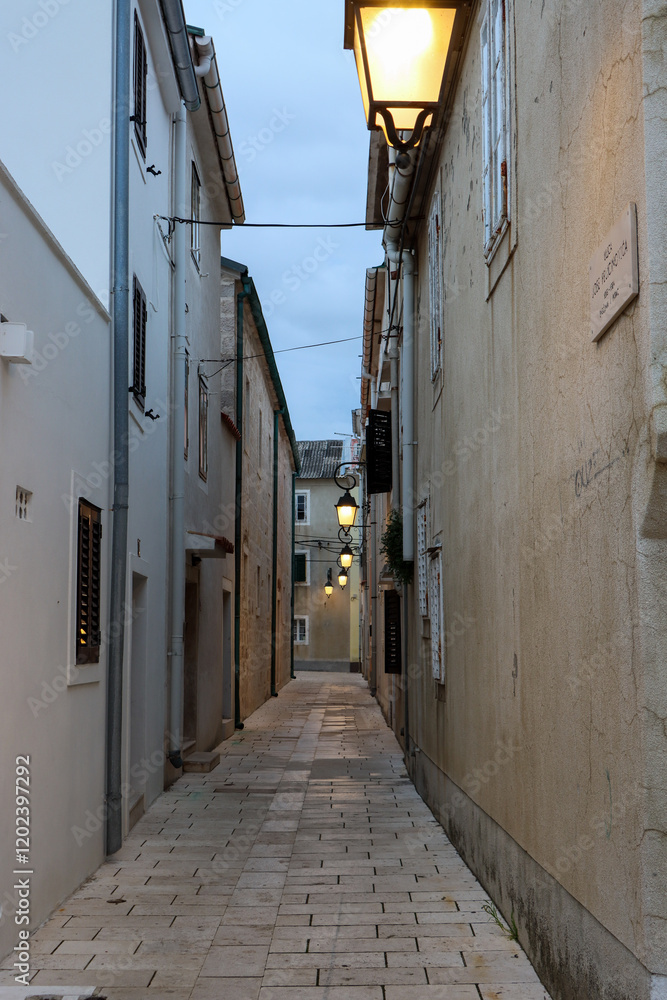 Fototapeta premium empty, ancient alley with street lamps in a historical setting at dusk. vertical photo