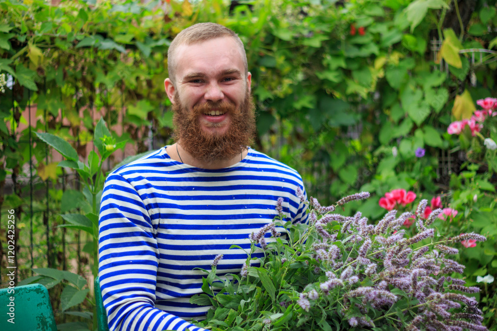 A man with a red beard laughs, holds a large bouquet of flowers, close-up portrait of a man, joy, happiness, summer, nature. A man with a red beard laughs, holds a large bouquet of flowers, close-up portrait of a man, joy, happiness, summer, nature.