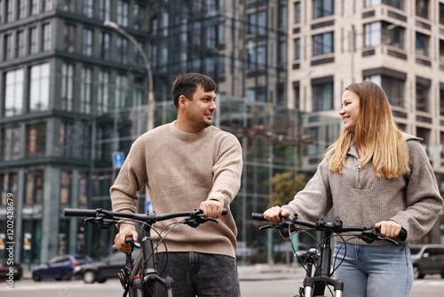 Beautiful happy couple with bicycles spending time together outdoors photo