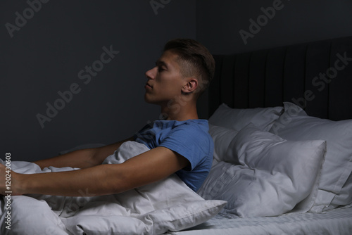 Young man suffering from sleepwalking on bed at home photo