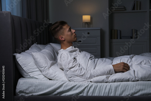 Young man suffering from sleepwalking on bed at home photo