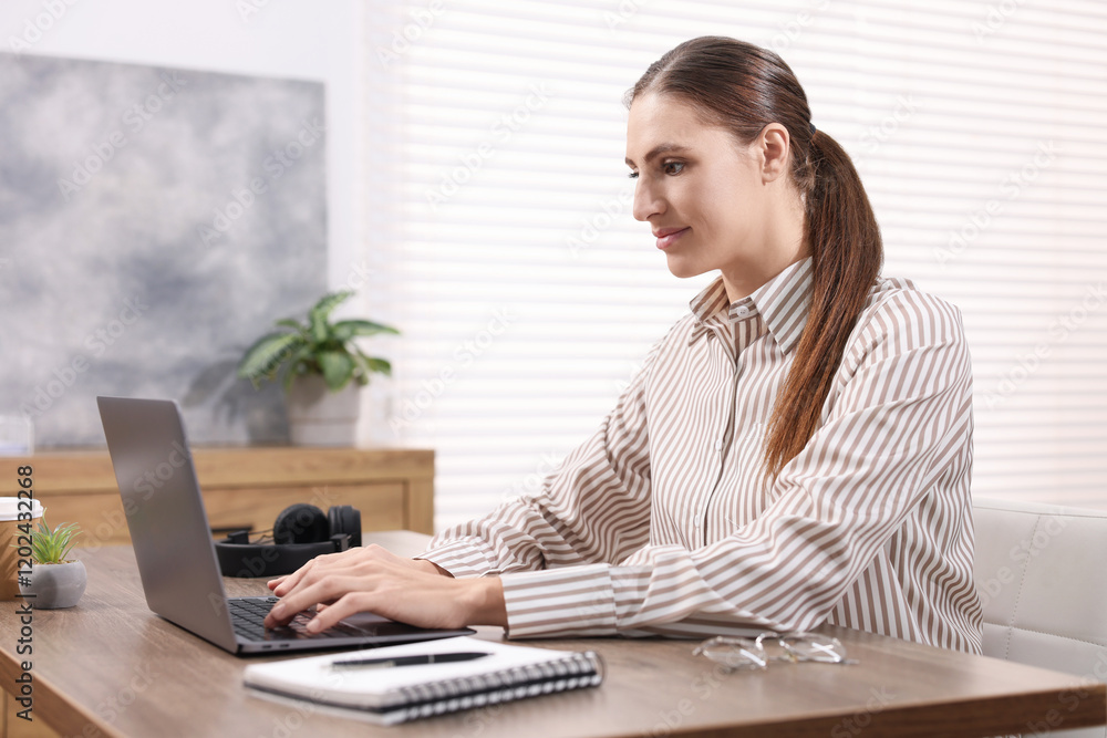 Programmer working on laptop at wooden desk indoors Programmer working on laptop at wooden desk indoors