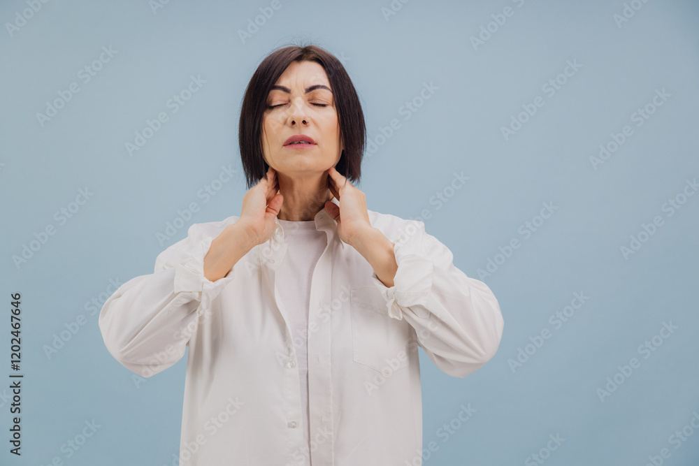 Middle aged woman suffering from neck pain touching her sore throat with closed eyes Middle aged woman suffering from neck pain touching her sore throat with closed eyes