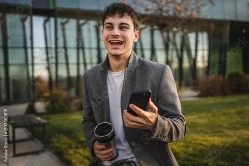 young adult man sit with thermos and use mobile phone on coffee break photo