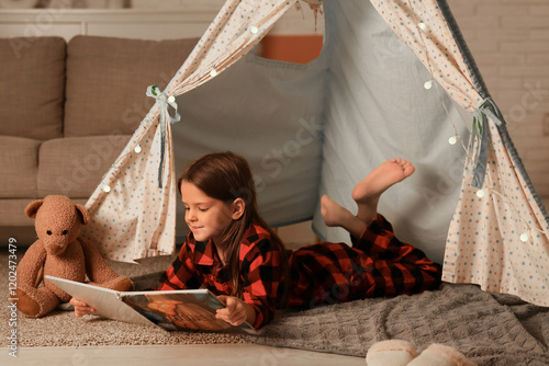 Cute little girl reading fa...