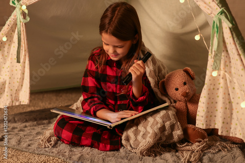 Cute little girl reading fa...