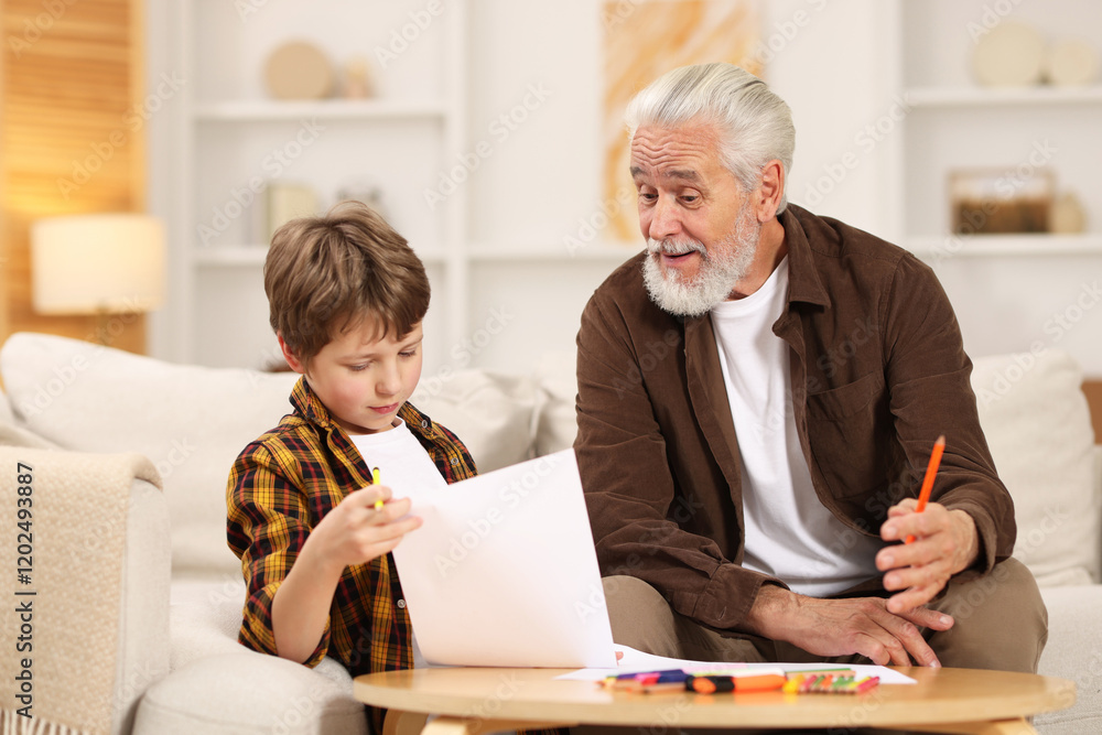 © New Africa - Grandpa and his grandson drawing at table indoors © New Africa - Grandpa and his grandson drawing at table indoors