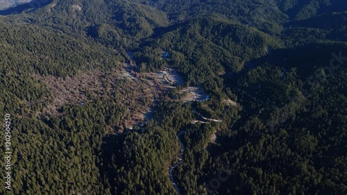 Lush green valleys interspersed with rugged cliffs in the Gyftokampos region of Zagori Greece, forest backdrop tilt up to peak photo