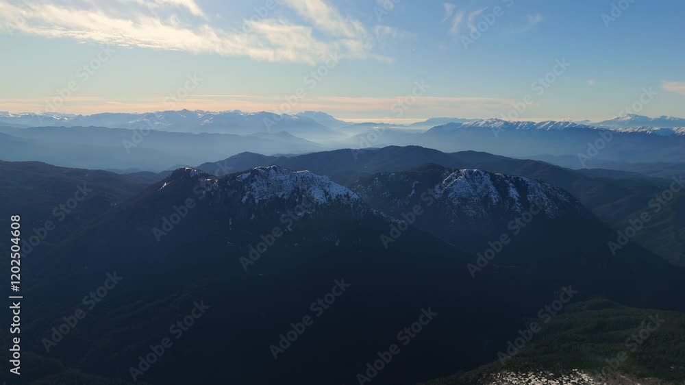 Dramatic view of snow laden mountain peaks at sunrise in Zagori, Greece Dramatic view of snow laden mountain peaks at sunrise in Zagori, Greece