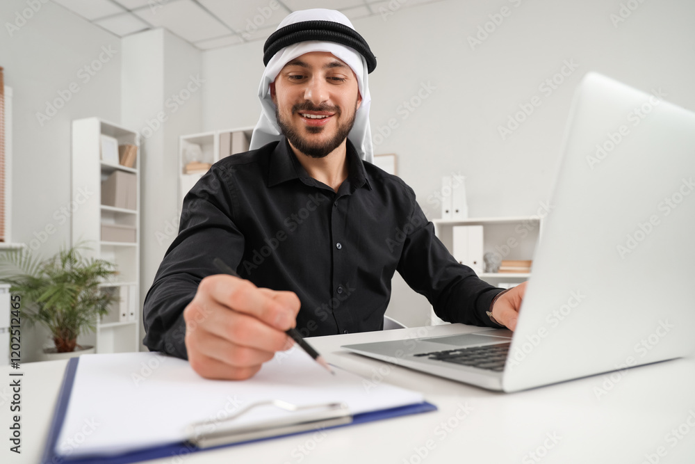 Arab businessman working with laptop at table in office Arab businessman working with laptop at table in office