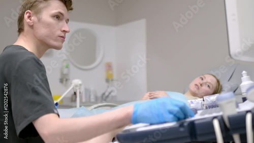 A gynecologist - ultrasound specialist performs an intervaginal ultrasound during a woman's appointment. Doctor shows an image of an early pregnancy on the ultrasound screen. IVF treatment protocols