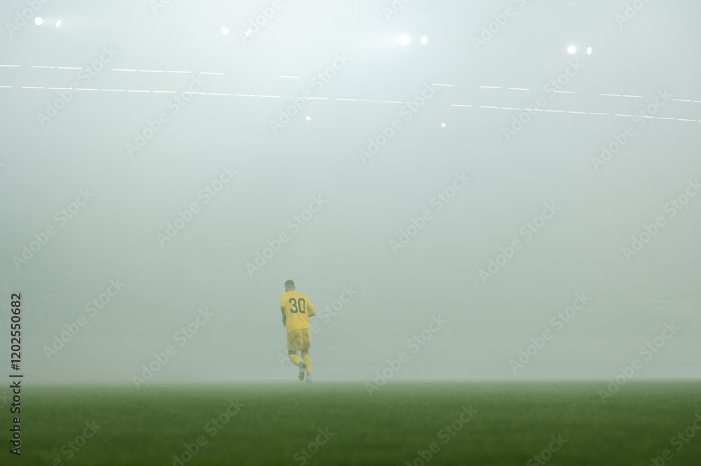 Footballer on the field during fog at the stadium
