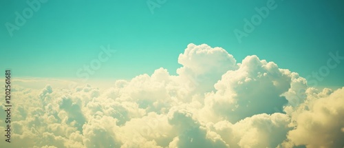 Fluffy white clouds float tranquilly in a vibrant cyan sky, capturing the essence of a peaceful, airy day above.