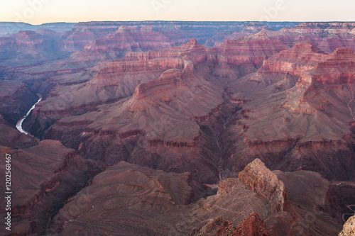 Éclat doré au Grand Canyon : Un coucher de soleil spectaculaire embrasant les falaises majestueuses d'un des paysages les plus emblématiques du monde