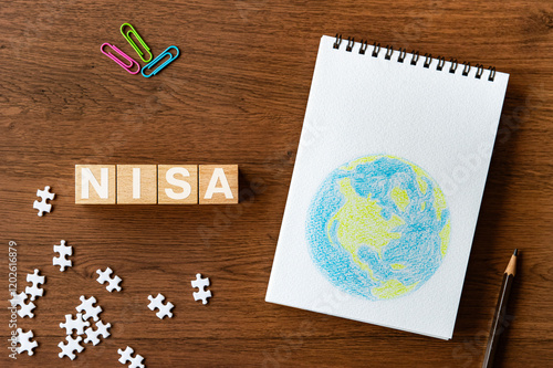 There is wood cube with the word NISA. It is an abbreviation for Nippon Individual Savings Account as eye-catching image. photo