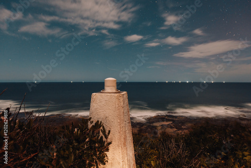 View from the Iluka Bluff lookout at night with lights of cargo ships visible along the horizon photo