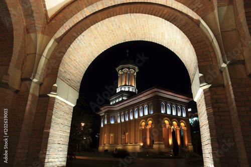 Canvas Print Illuminated church at night with a high tower, blue sky and visible windows