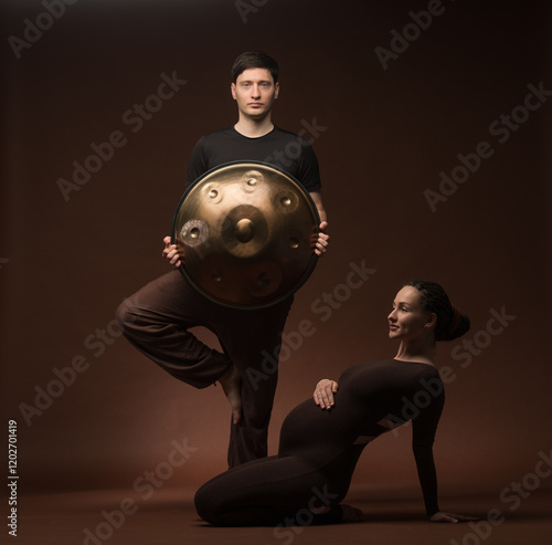 pregnant woman with man and percussion in yoga pose photo