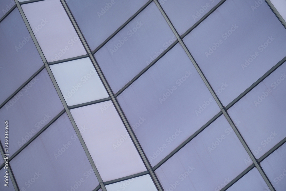 A modern office building facade with large glass windows that reflect its surroundings