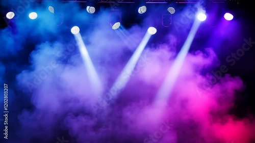Blue and white stage lights illuminating a cloud of smoke during a performance at a concert venue