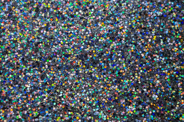 Full frame macro abstract texture background of a sparkling multi color confetti glitter surface
