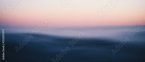 Dreamy seascape with blurred waves beneath a soft pink and blue sunset sky evokes tranquility and introspection.